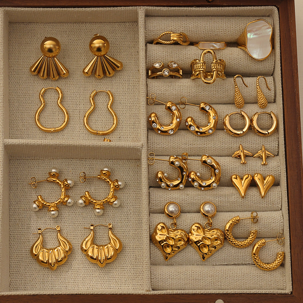 Collection of gold plated rings and earrings featuring the Pressie Bold Link Statement Ring
