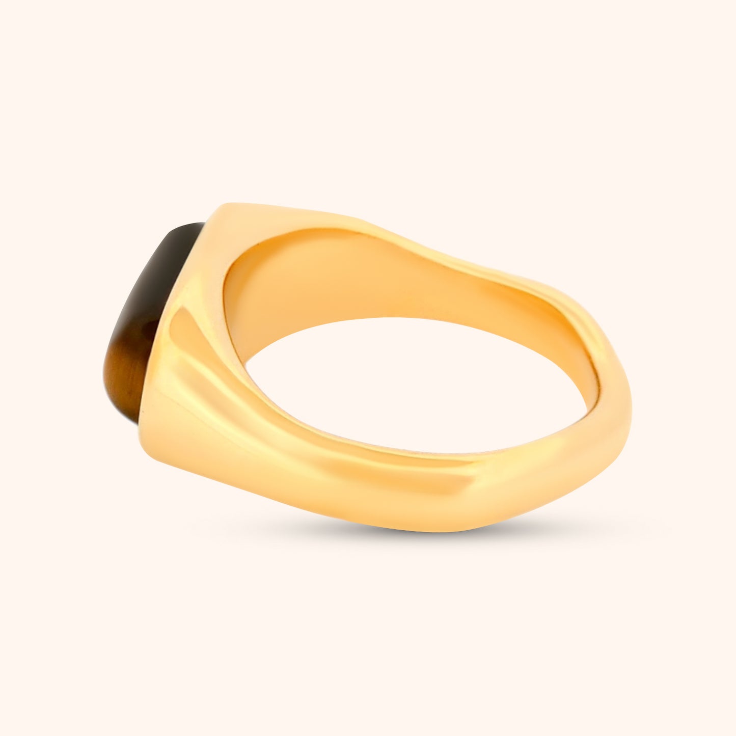 The Marbella Ring on a finger, demonstrating its elegant size and how the Tiger's Eye stone complements the gold band.