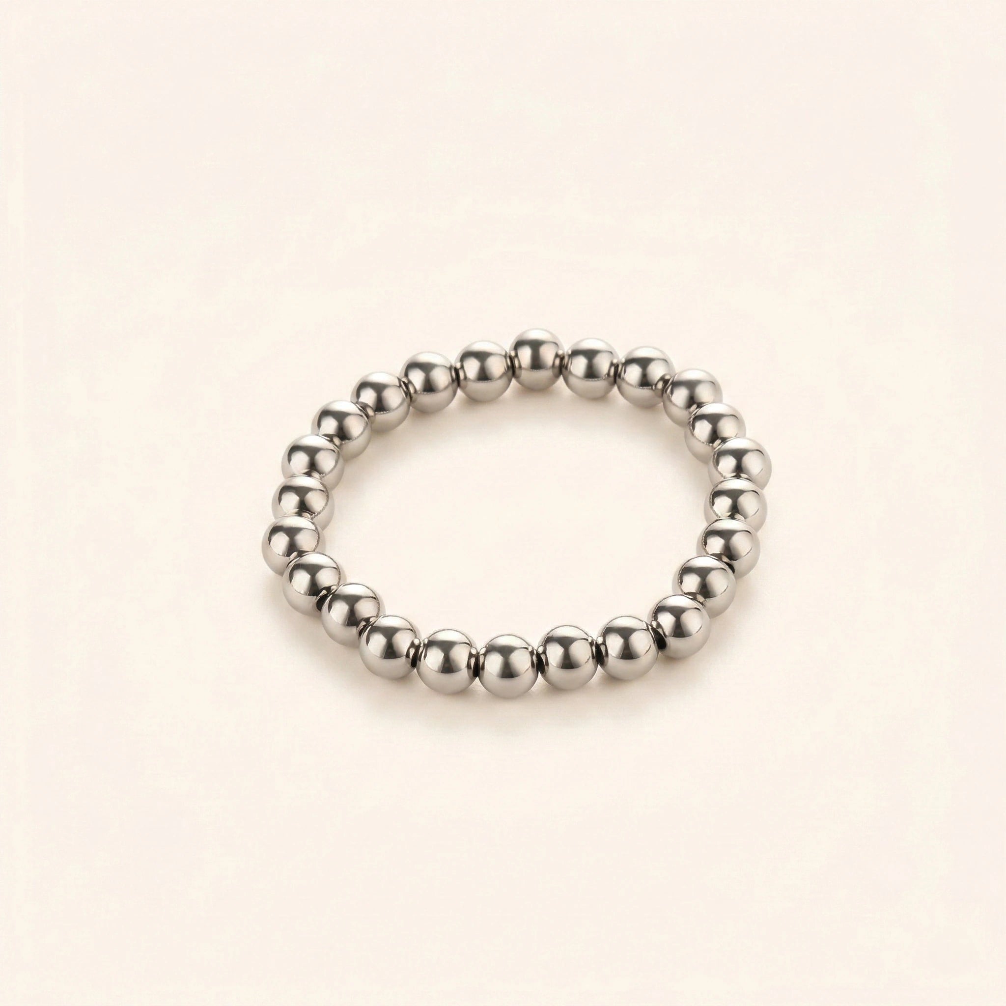 Silver beaded ring on a beige background
