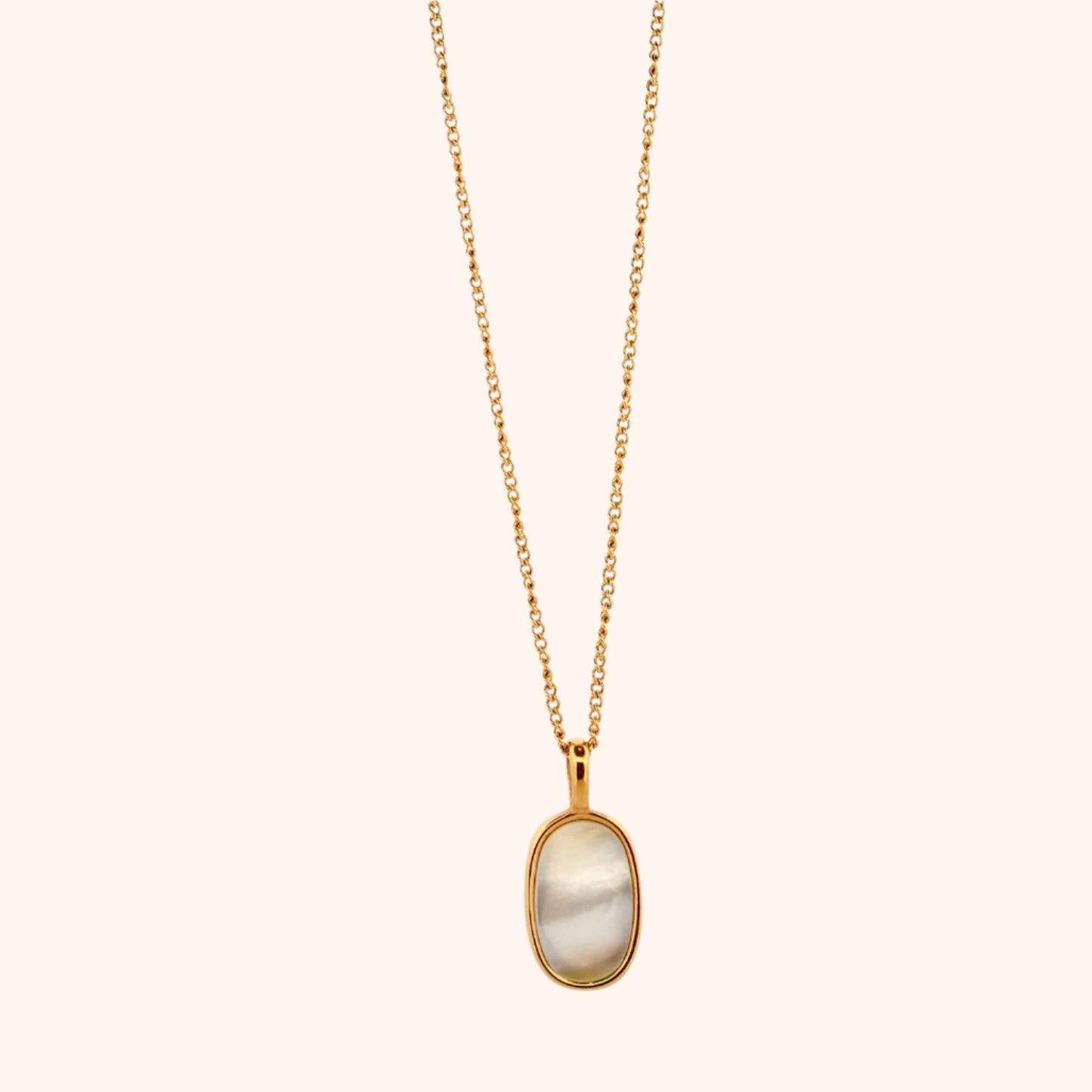 Close-up of The Cozumel Necklace's oval pearl pendant, showcasing its lustrous surface and elegant setting on a delicate gold chain.