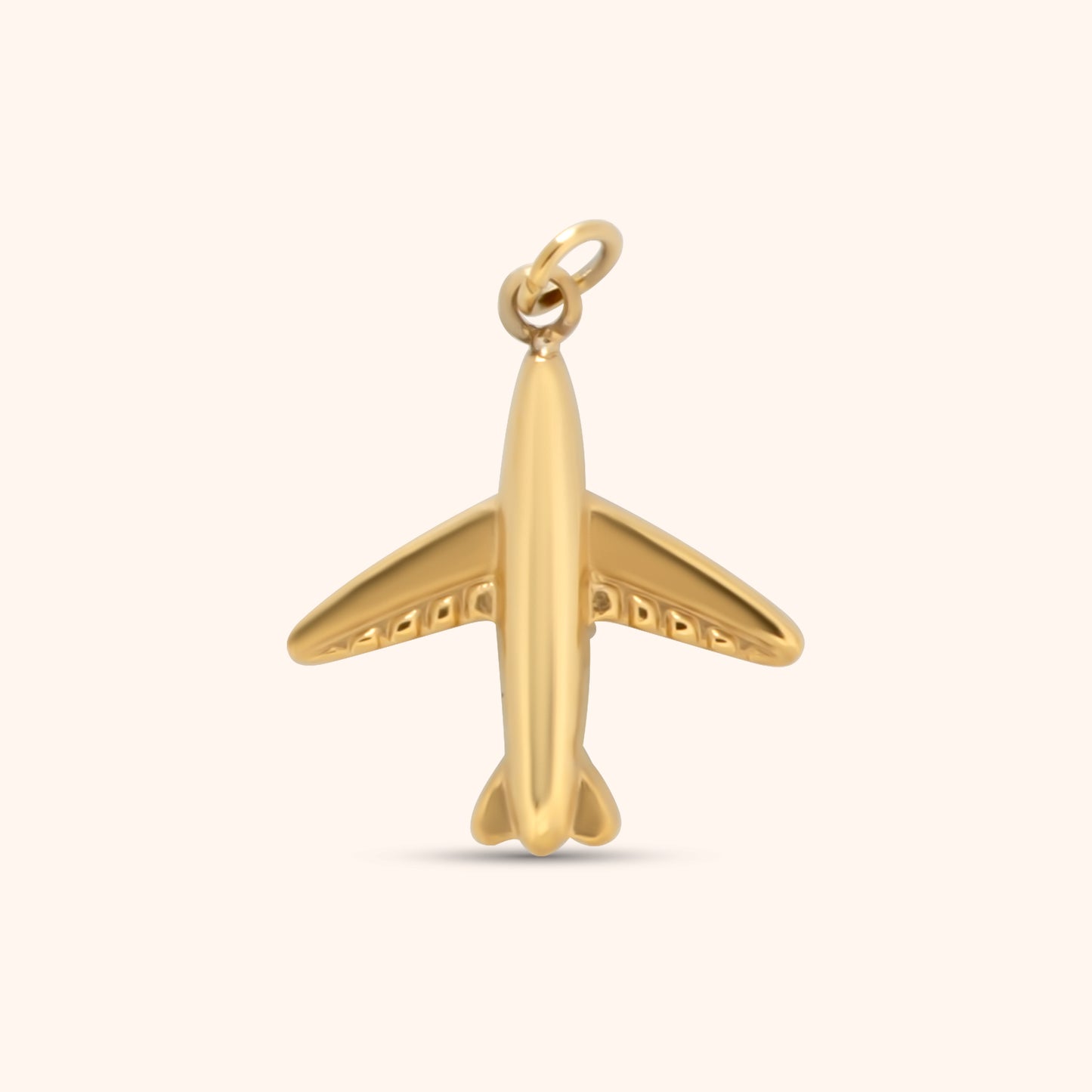 Gold airplane-shaped charm with smooth finish and rounded details, made of 18k gold plated stainless steel