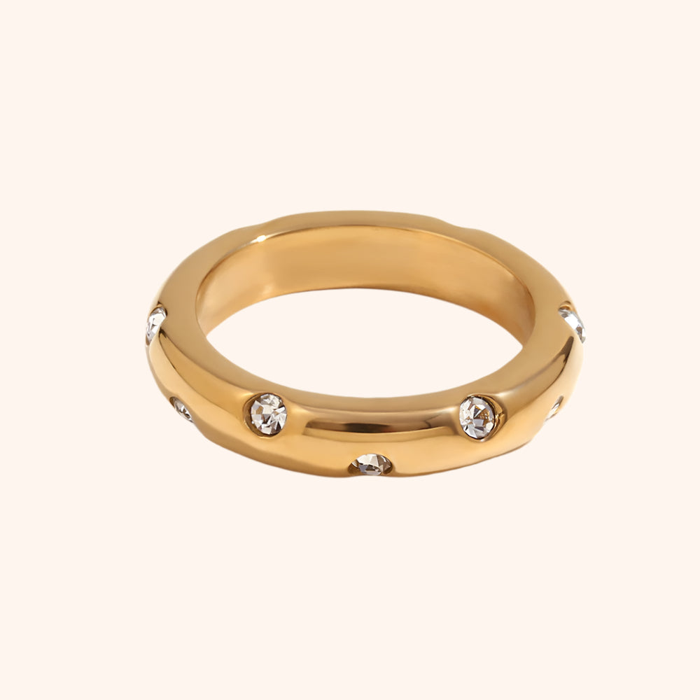 Gold ring with embedded crystals on a white background
