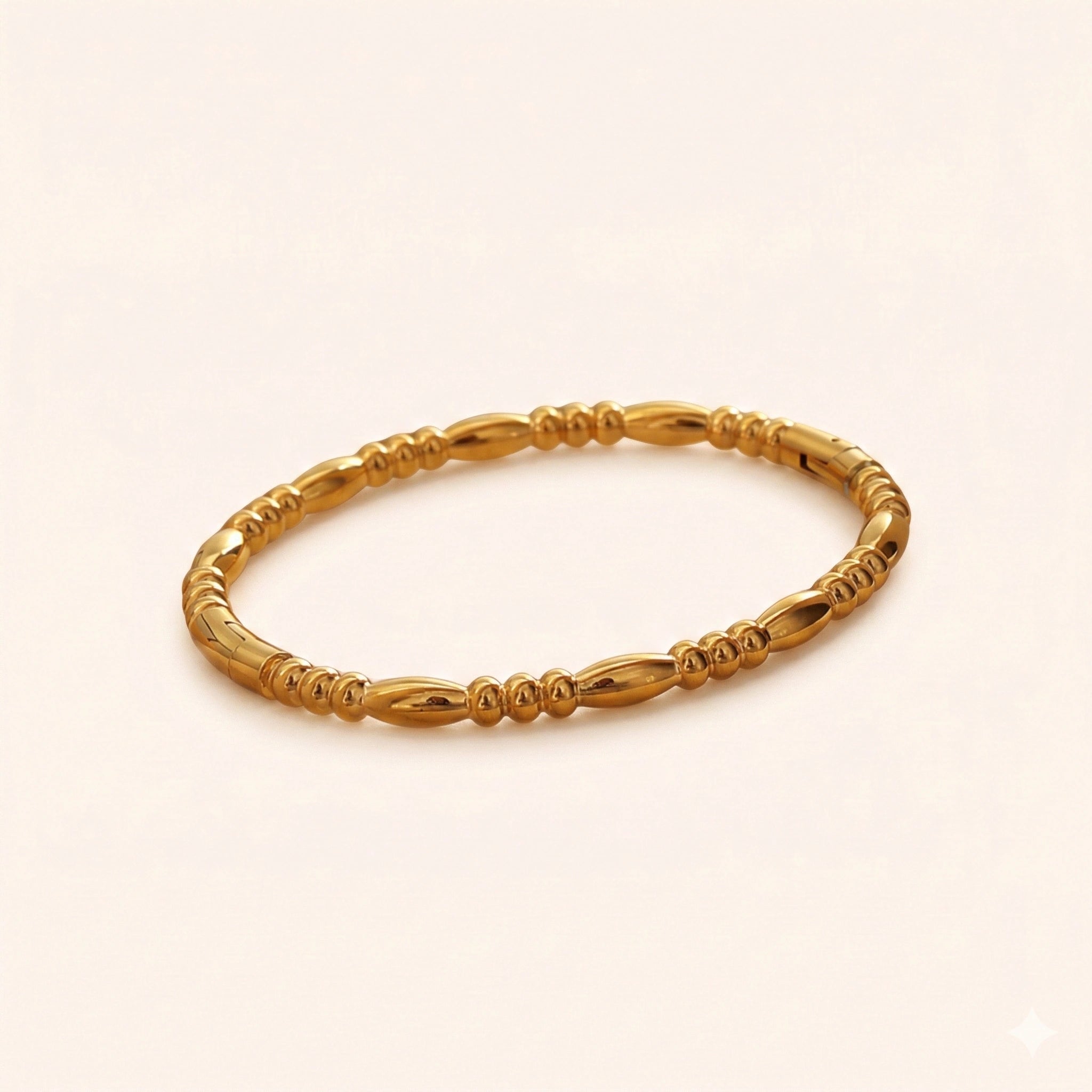 Gold bracelet on a light beige background