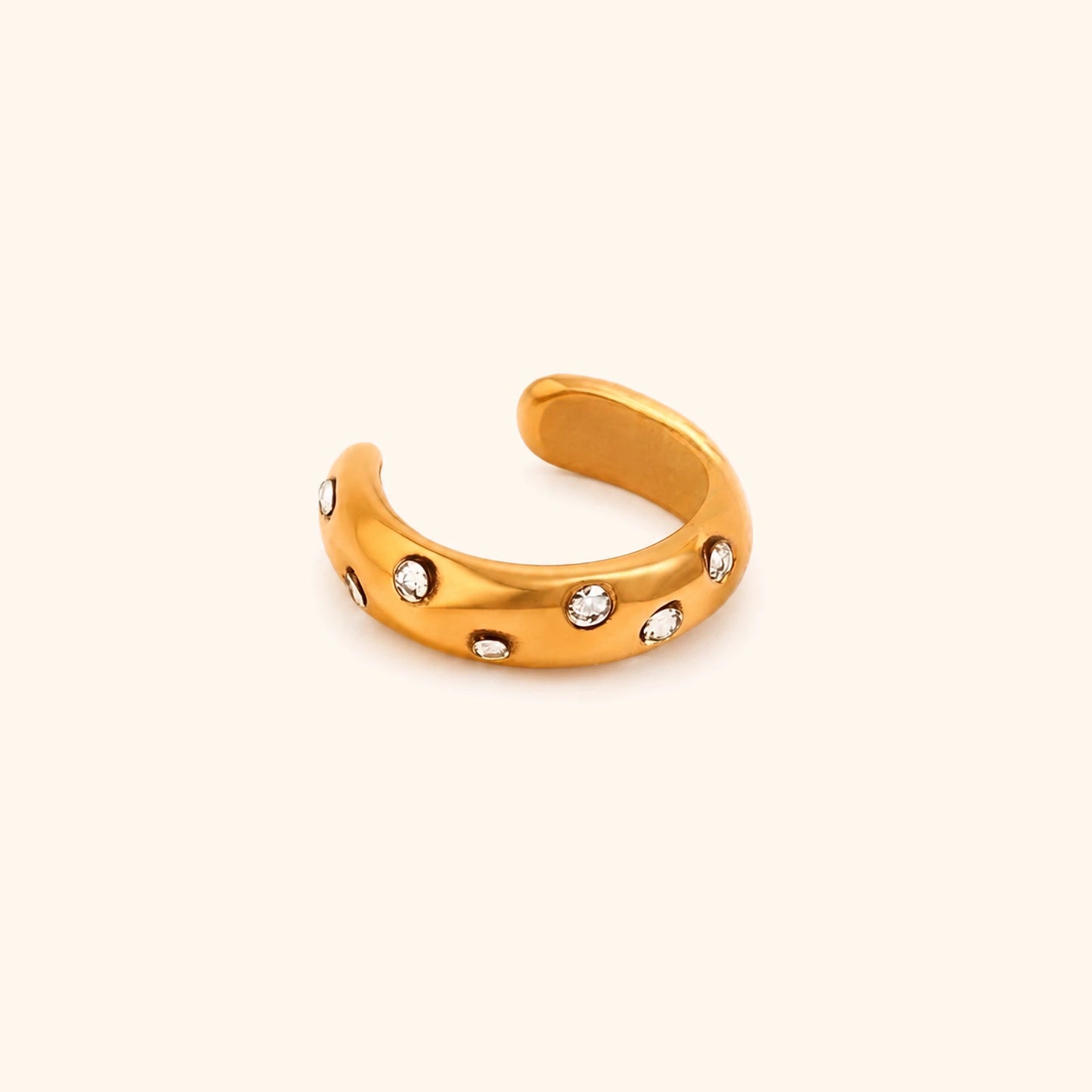Gold open toe ring with small diamonds on a beige background