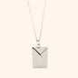 Close-up of a silver functional envelope necklace pendant, showcasing its detailed design and elegant style.

