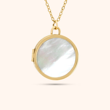 Close-up of the PRESSIE Treasured Locket; an 18k gold plated round locket with an iridescent mother-of-pearl front inlay.