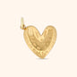 Close-up of the Amour Charm, a gold heart-shaped charm with a textured surface.