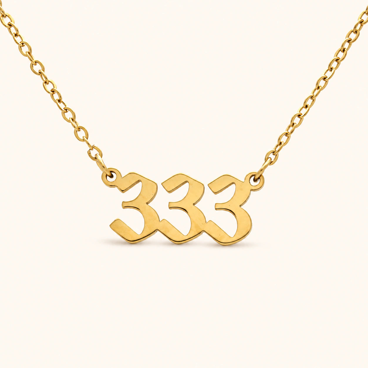 333 18k gold angel number necklace with bold numeral pendant on a gold 