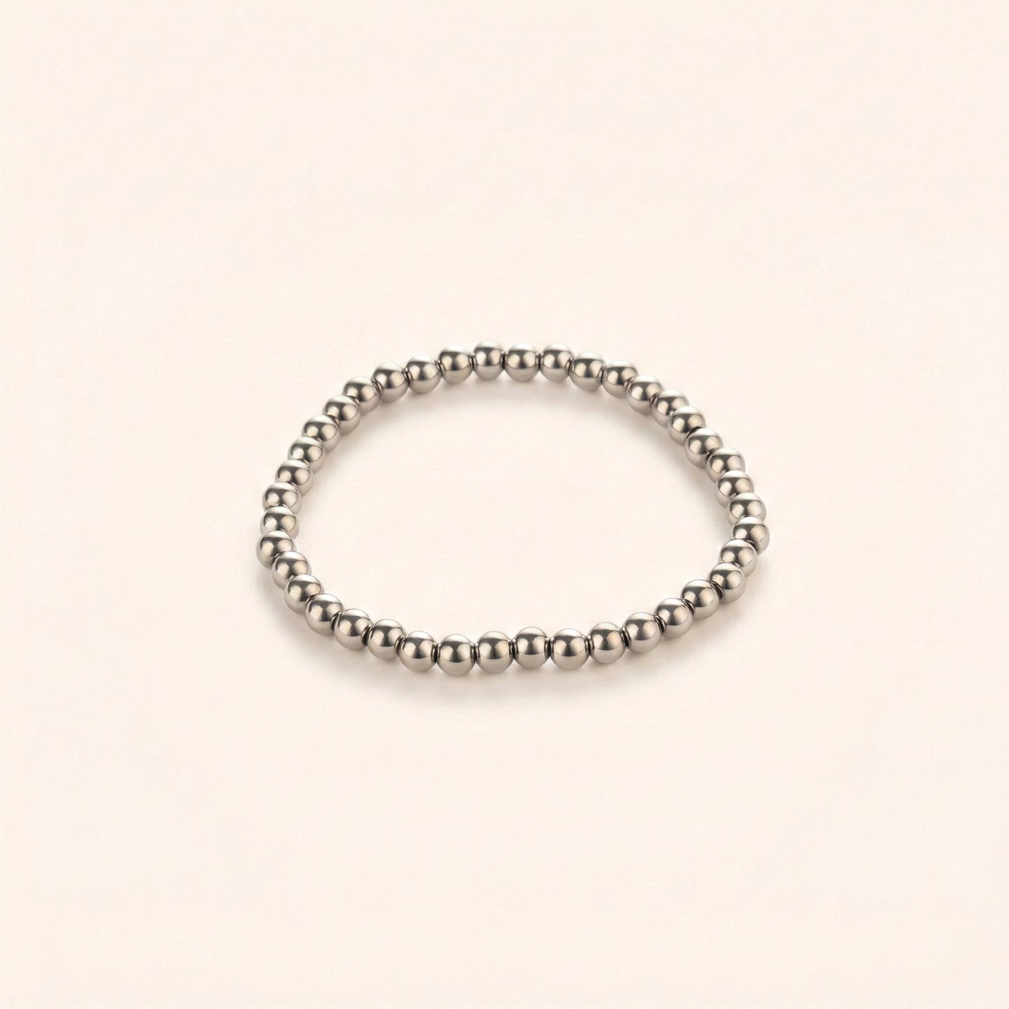 Silver beaded bracelet on a beige background