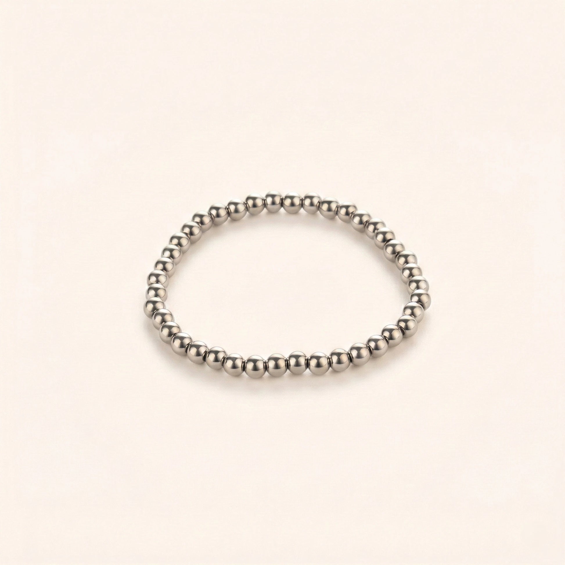 Silver beaded bracelet on a beige background