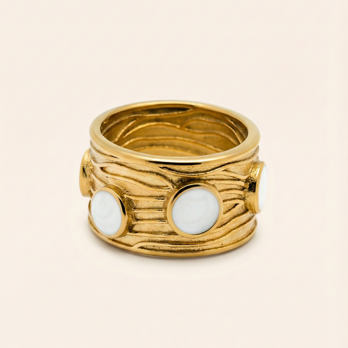 Gold ring with white stones on a beige background