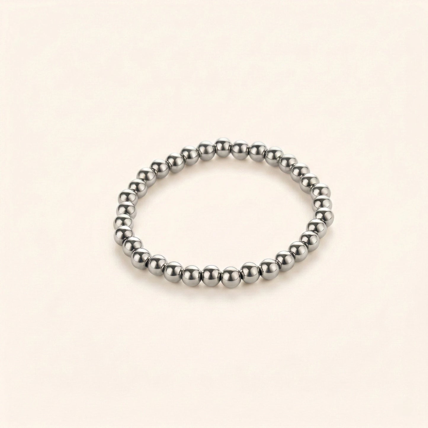 Silver beaded bracelet on a beige background