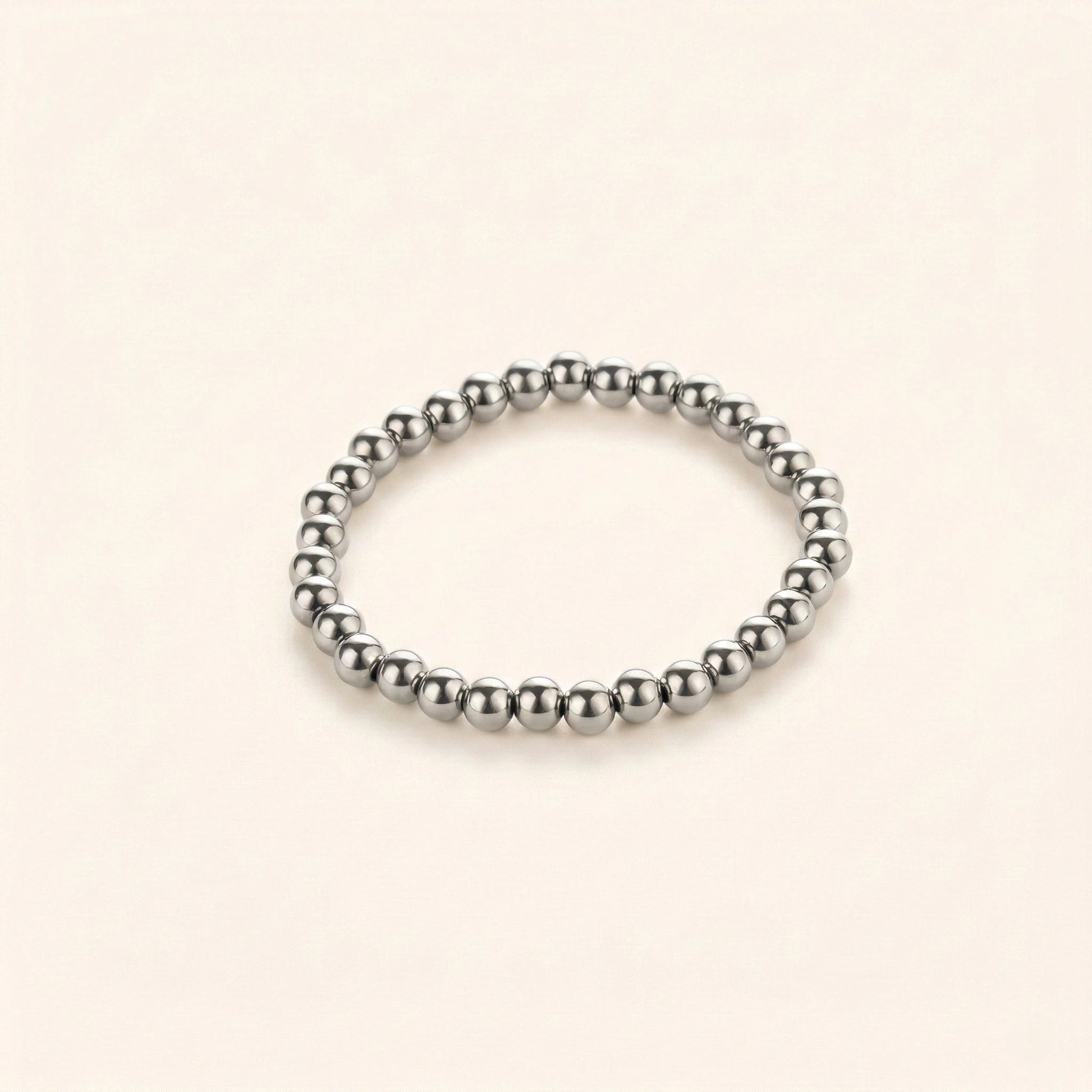 Silver beaded bracelet on a beige background