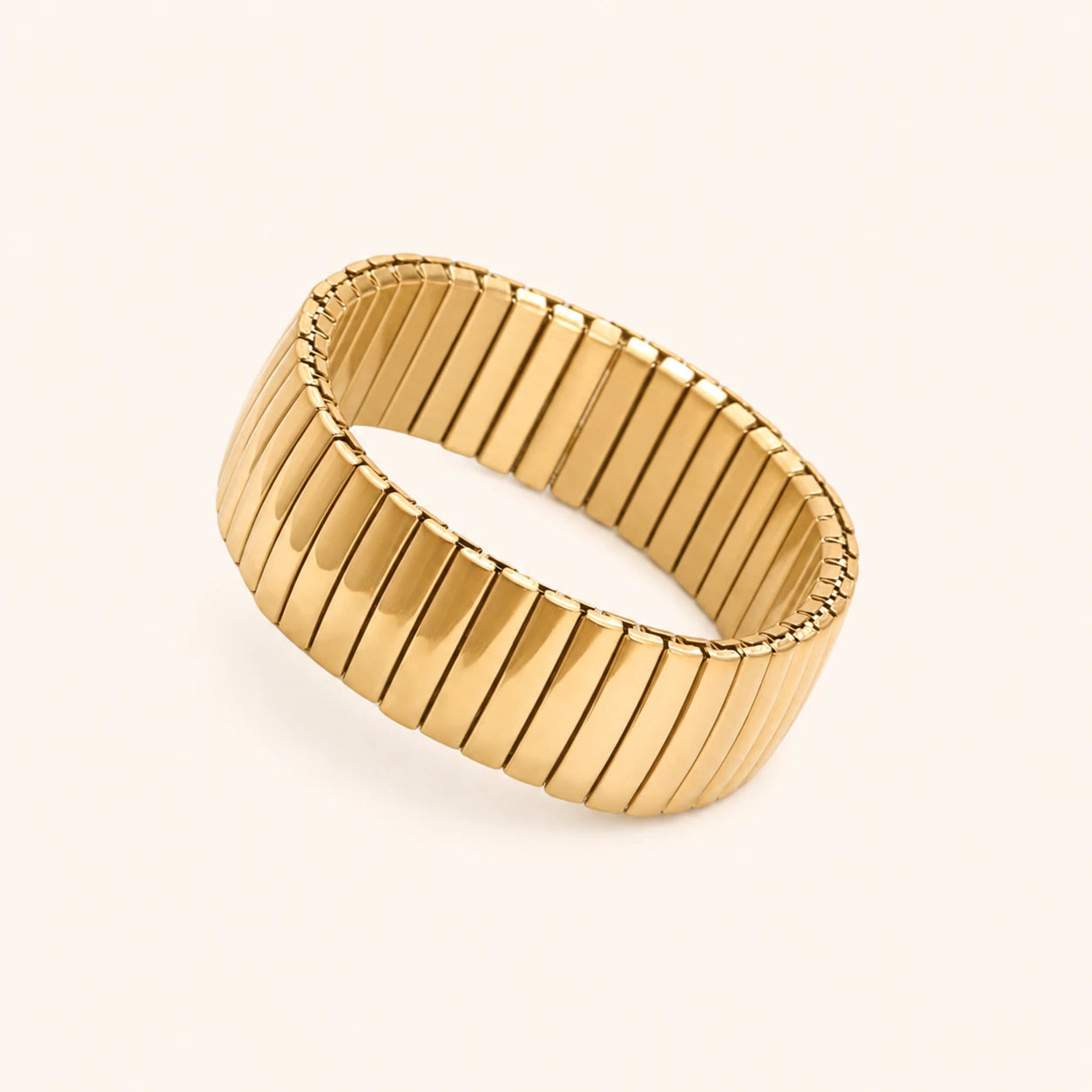 Gold ring with ribbed texture on a light beige background