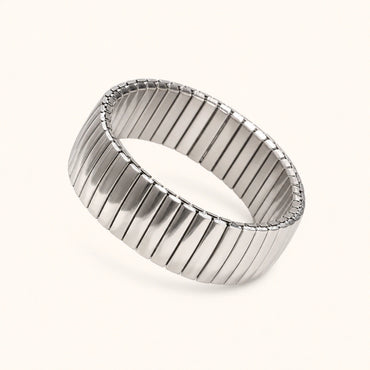 Silver bracelet with a ribbed design on a white background