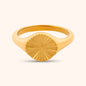 Close-up of the Helios Ring, a gold ring featuring a circular design with radiating lines, resembling a stylized sun.