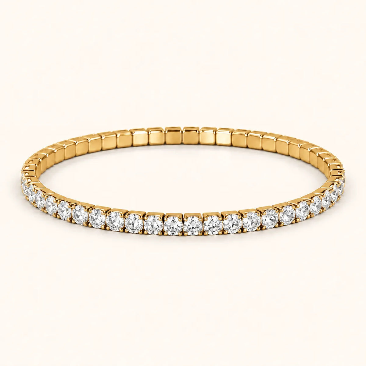 A yellow gold tennis bracelet featuring a continuous row of round-cut clear gemstones, presented on a clean, solid off-white background.