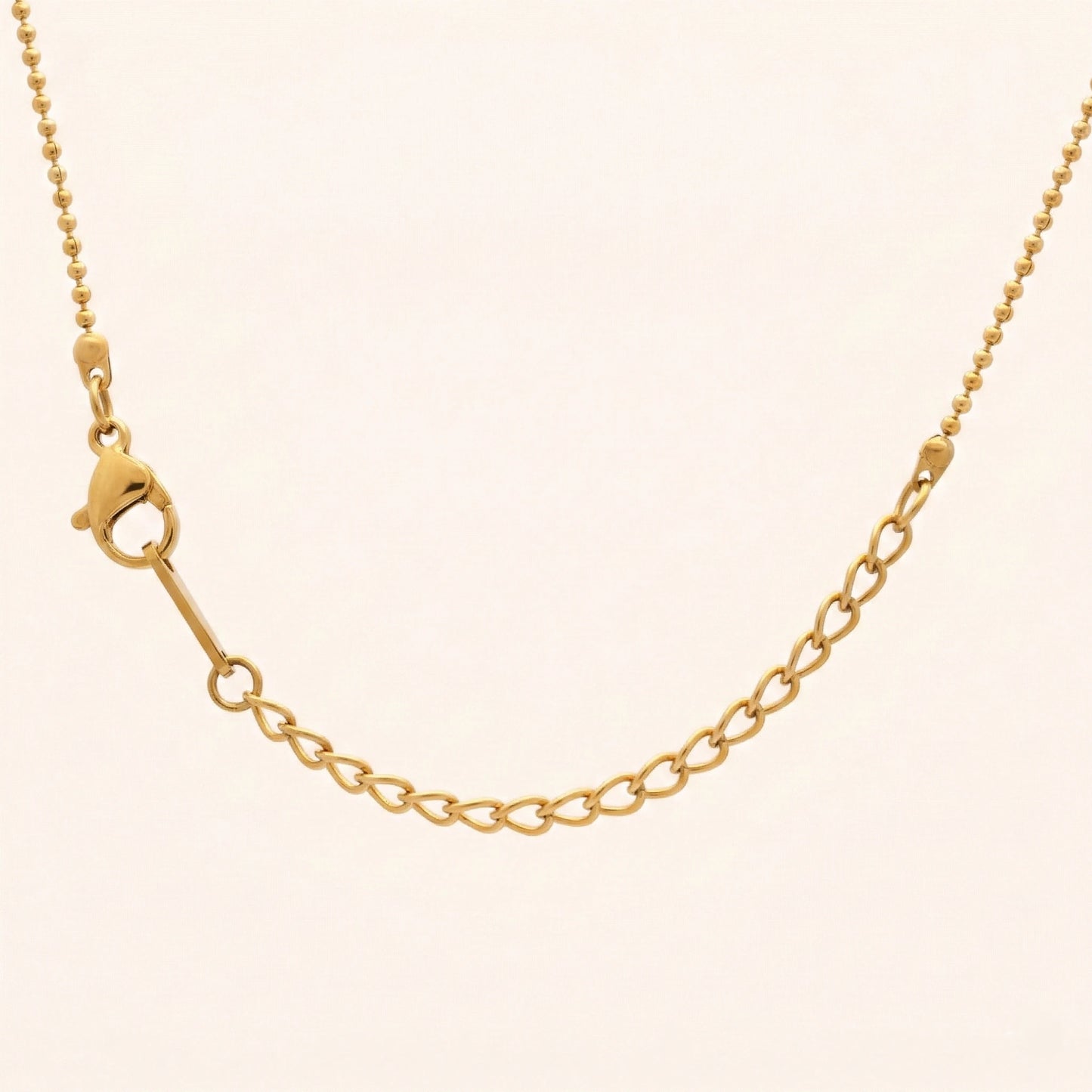 Gold chain necklace on a beige background