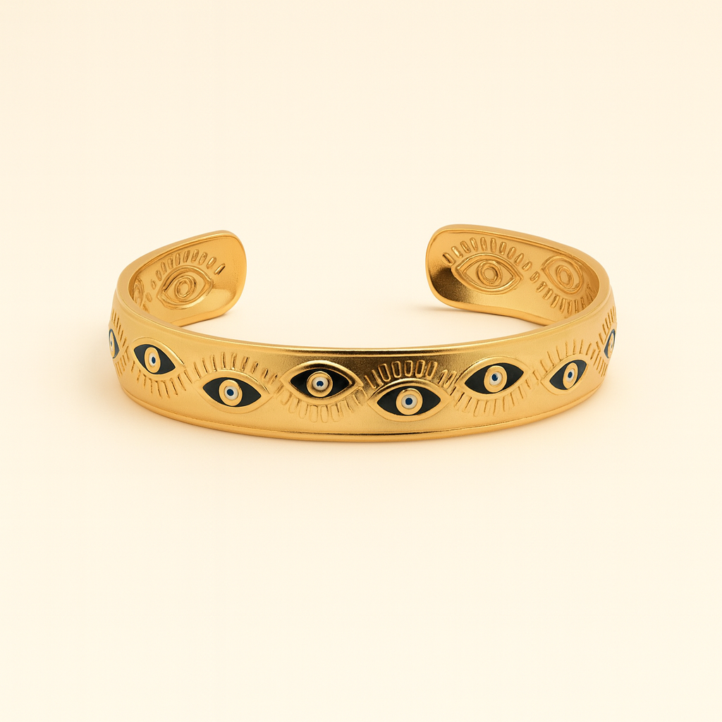 Gold bracelet with eye designs on a beige background