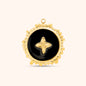 Round black and gold charm with starburst emblem at center and textured gold border, made of 18k gold plated stainless steel