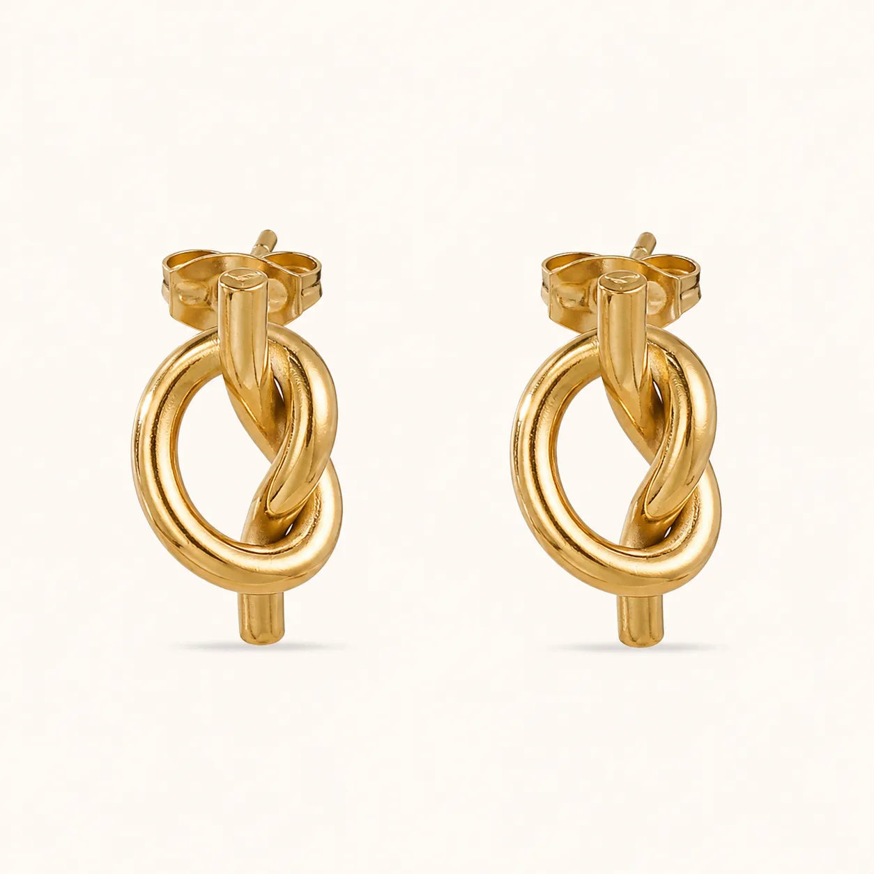 A pair of gold hoop earrings with a twisted knot design, shown on a clean off-white background.