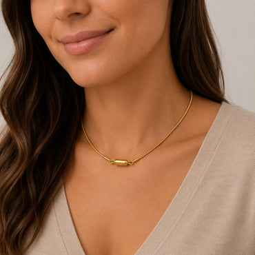 Woman wearing a gold necklace with a neutral background