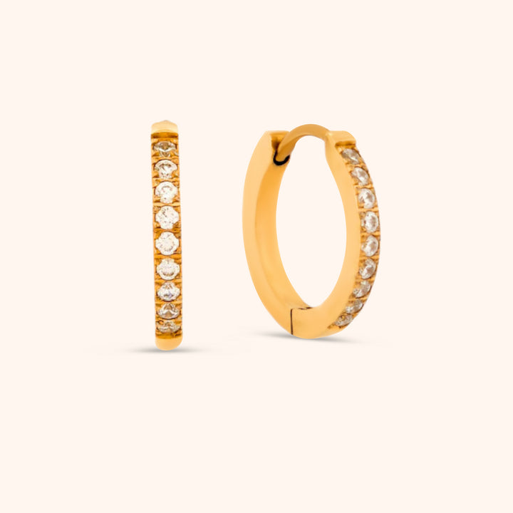 Close-up of 14k gold plated huggie earring with cubic zirconia stones, waterproof and hypoallergenic