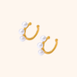 Pair of gold ear cuffs featuring three white pearls on each cuff, made of 18k gold plated stainless steel with a non-pierced design