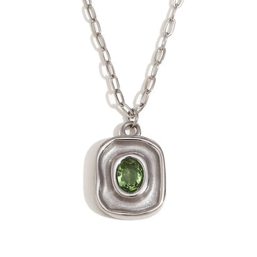 Silver pendant with a green gemstone on a white background