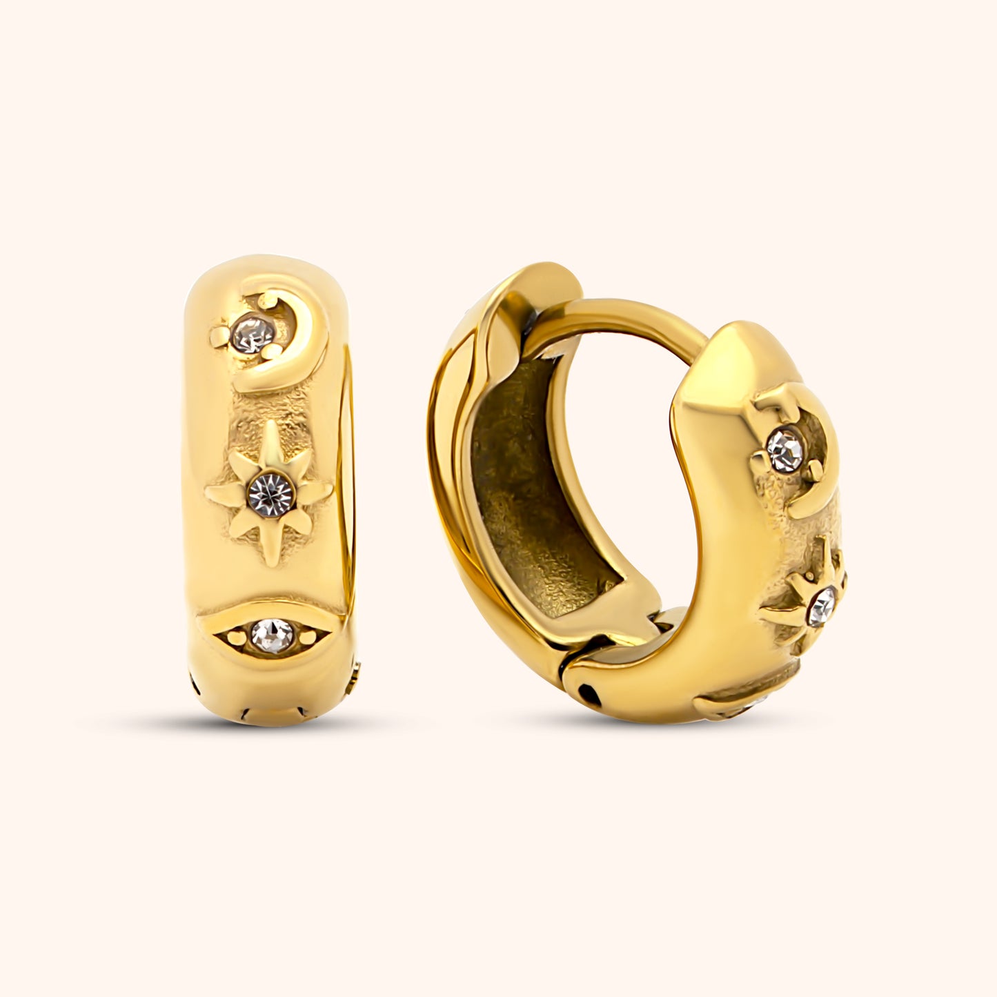 A pair of gold-colored huggie earrings with intricate designs and small, embedded stones.