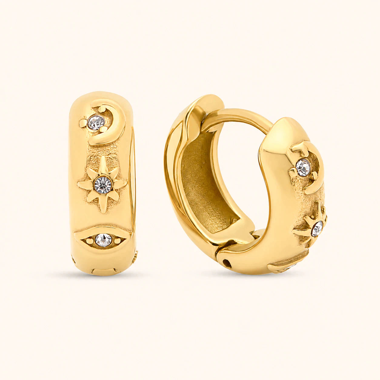 Gold hoop earrings with intricate designs and small stones on a white background