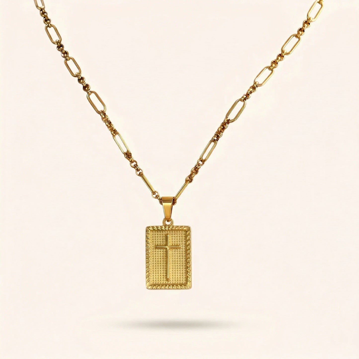 Gold necklace with a square pendant on a beige background