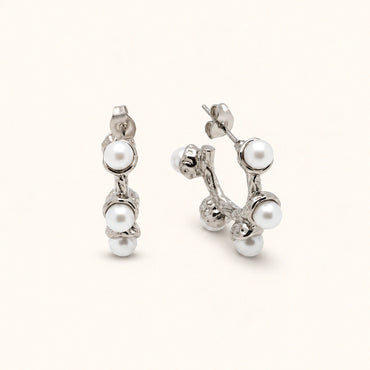 Pair of silver earrings with pearls on a white background