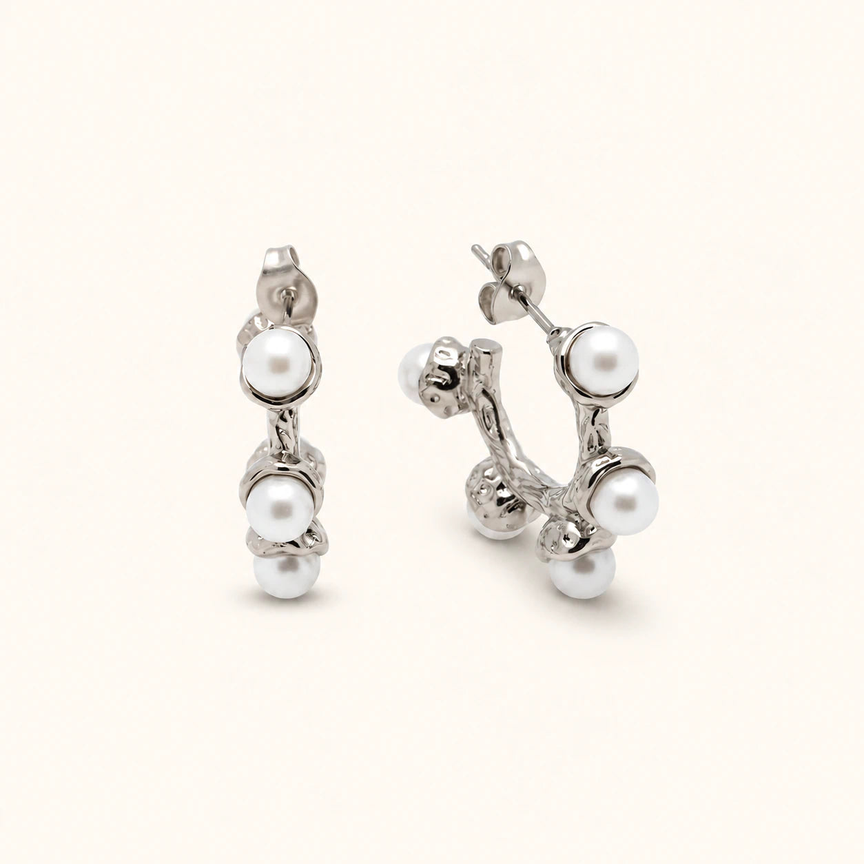 Pair of silver earrings with pearls on a white background