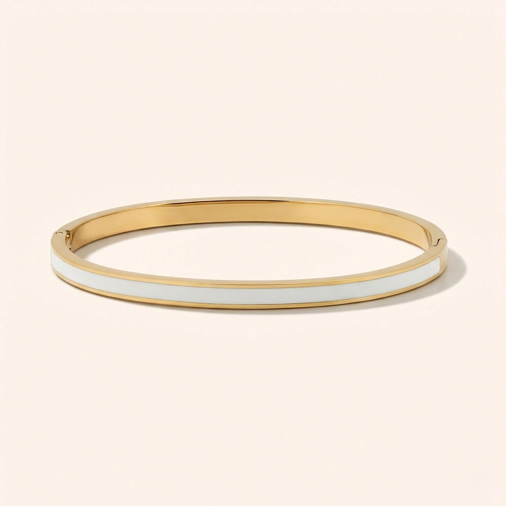Gold bangle with white interior on a beige background