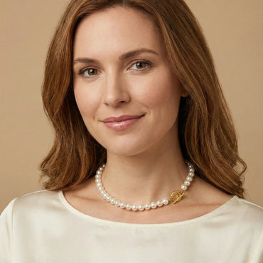 Woman wearing a pearl necklace against a beige background