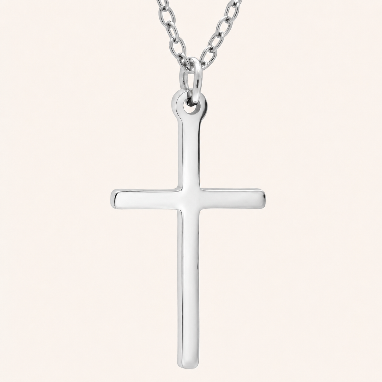 Silver cross pendant on a chain against a white background