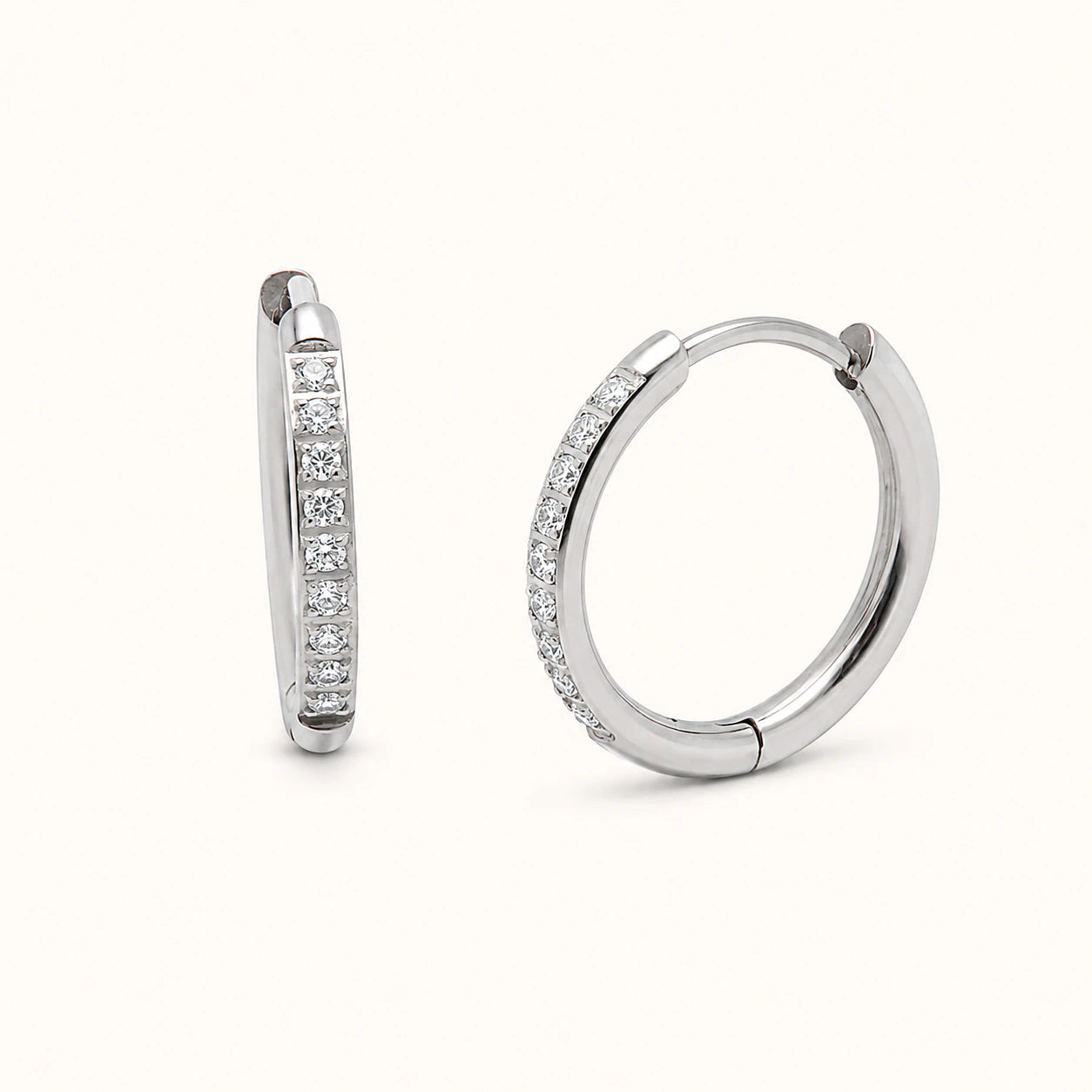 Pair of silver hoop earrings with embedded diamonds on a white background
