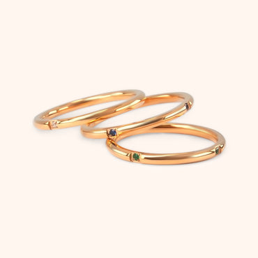The Unity Ring Set, showcasing individual delicate gold rings, possibly worn on a hand to demonstrate stacking options.
