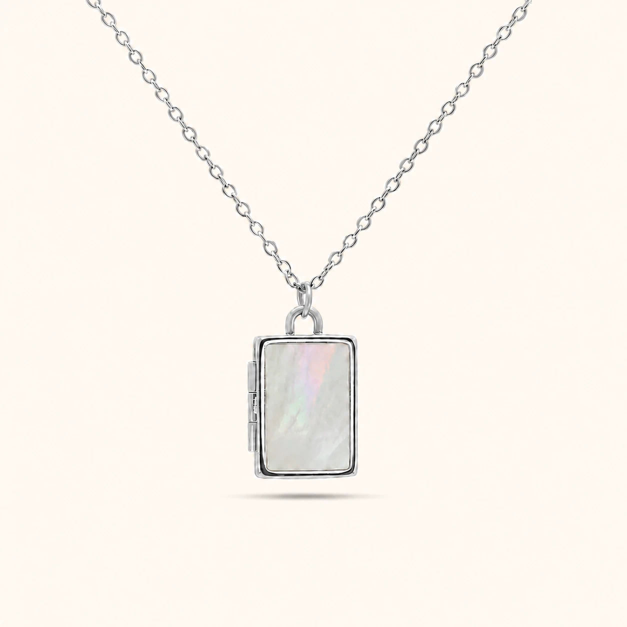 Silver necklace with a rectangular pendant on a white background