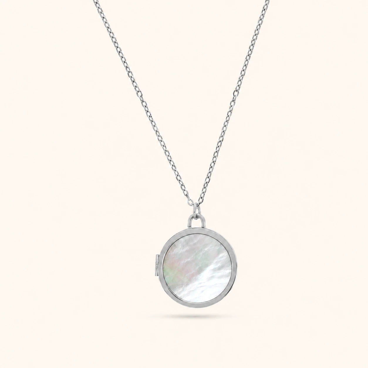 Silver necklace with a round pendant on a white background