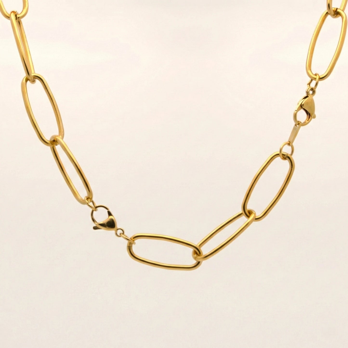 Gold chain necklace on a beige background