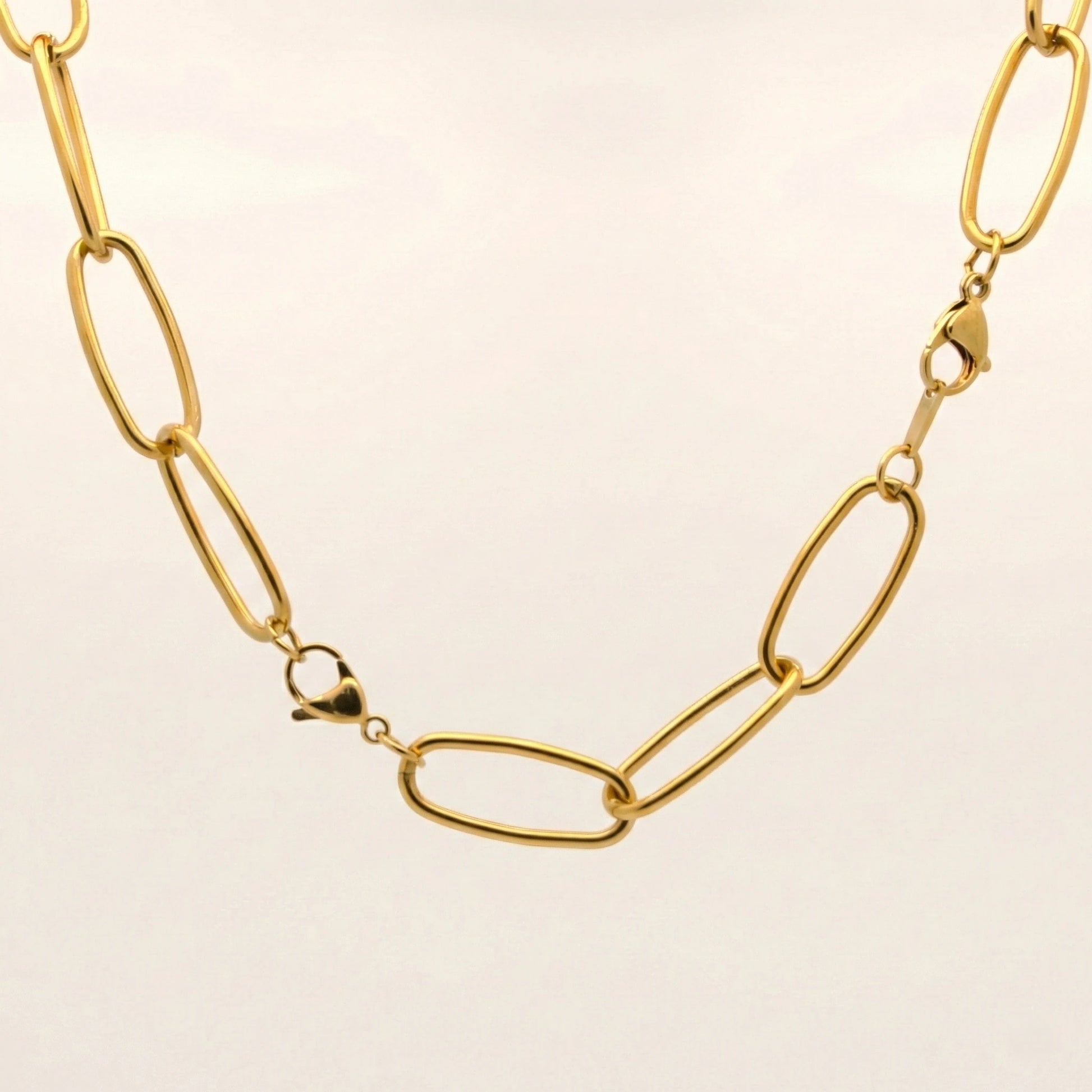 Gold chain necklace on a beige background