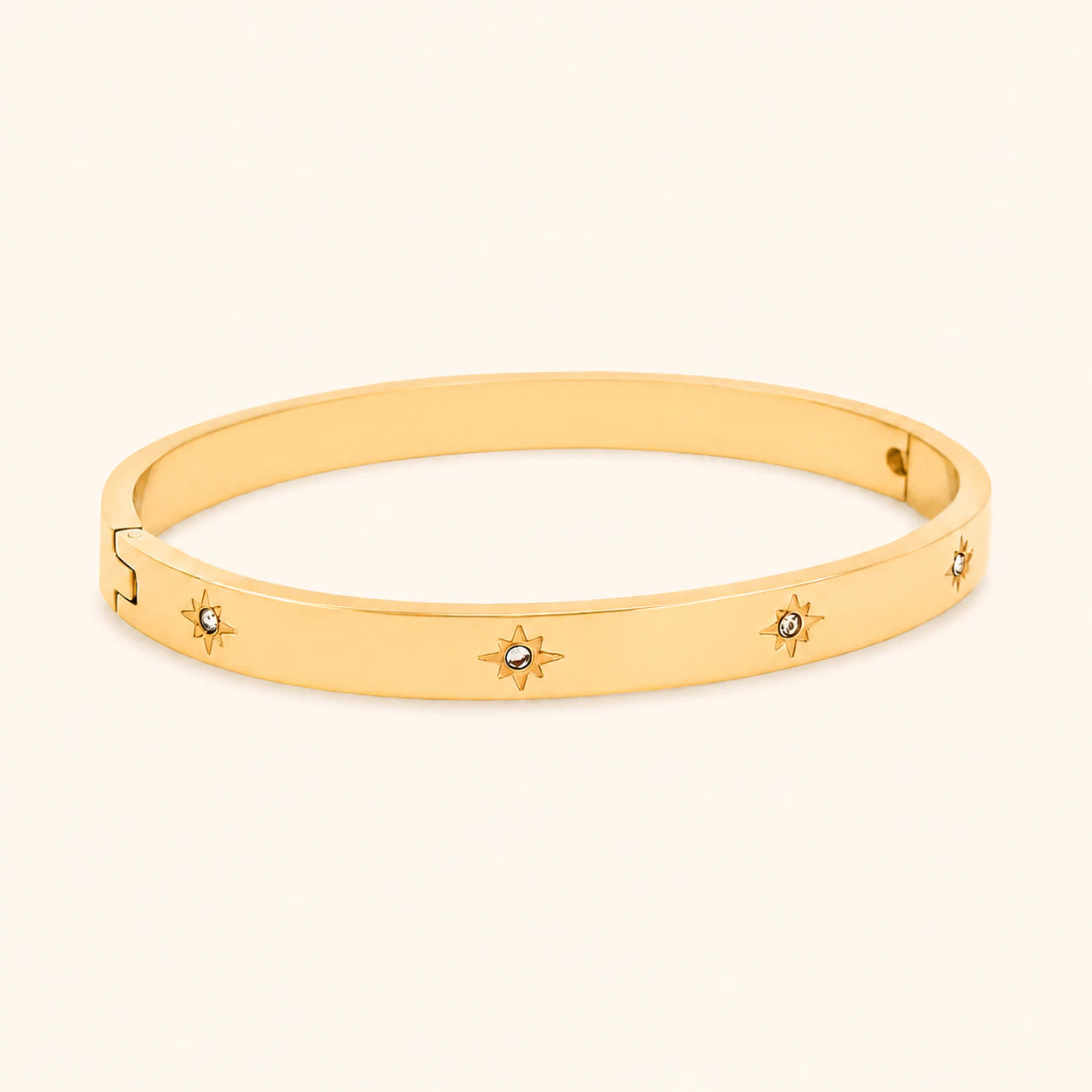 Gold bracelet with star designs on a light beige background