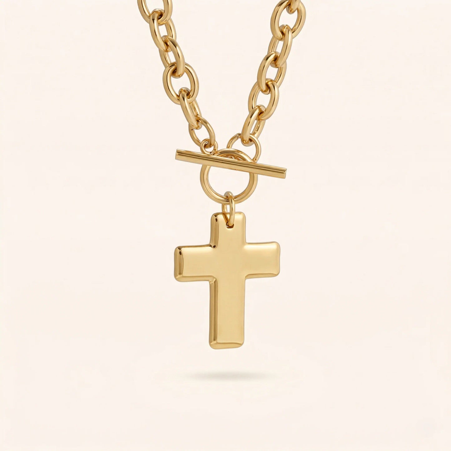 Chunky toggle necklace with a smooth cross pendant in gold.