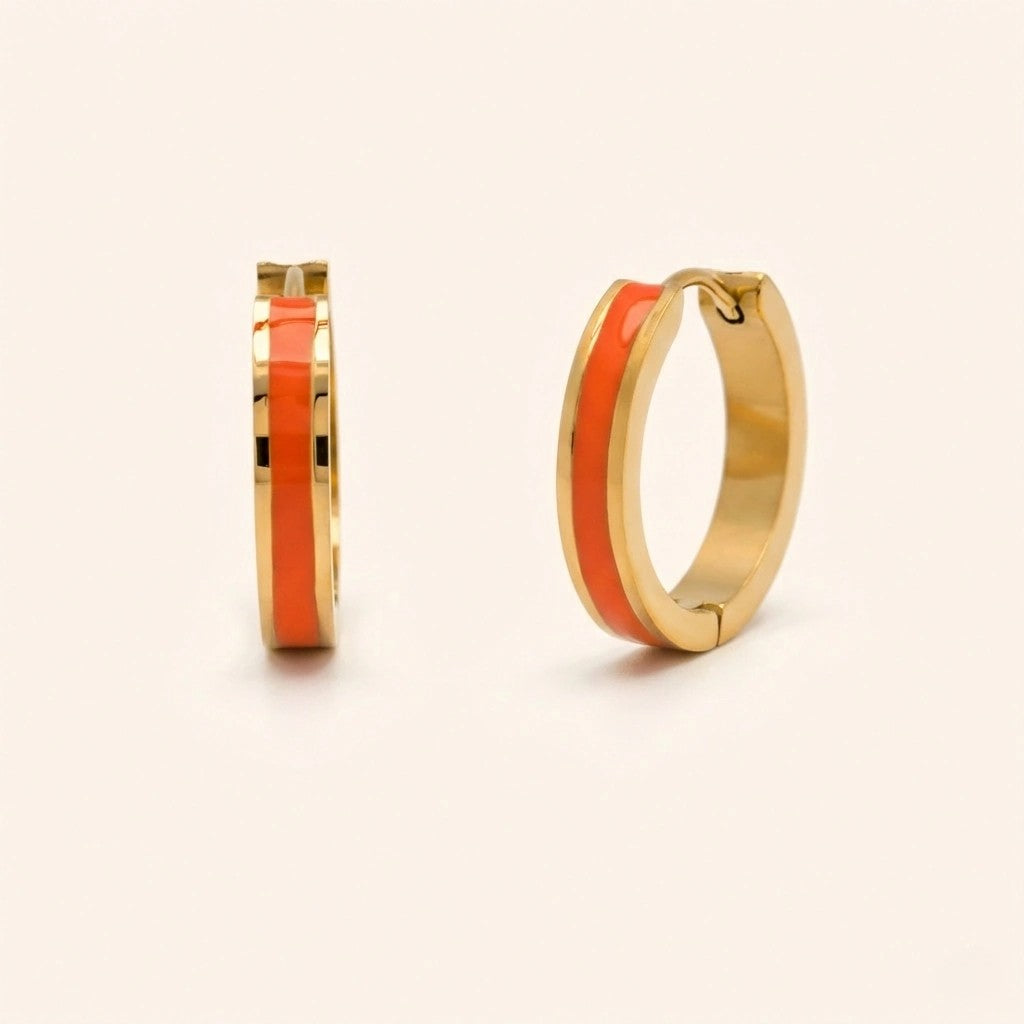 Gold hoop earrings with orange interior on a beige background