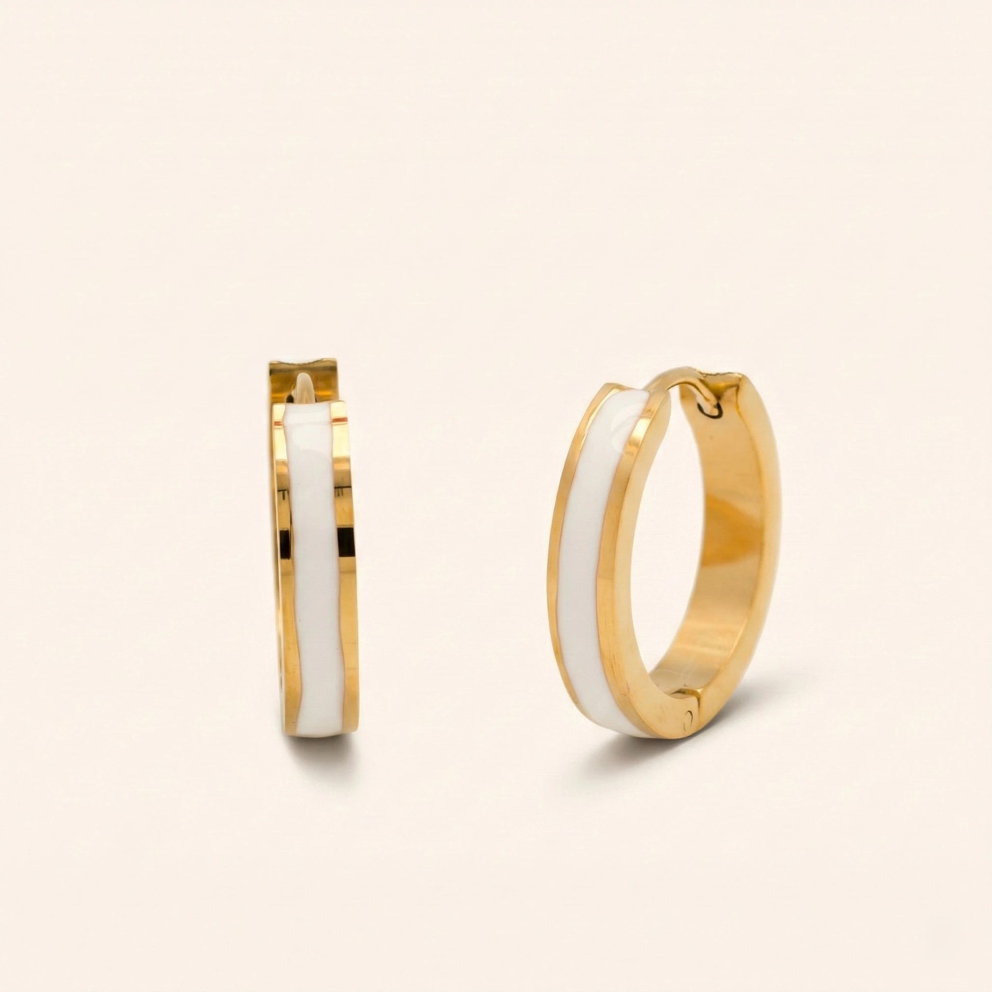 Gold hoop earrings with white interior on a beige background