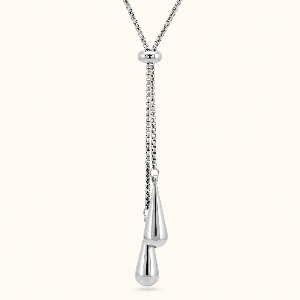Silver necklace with a teardrop pendant on a white background