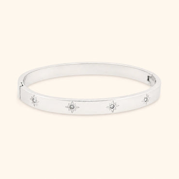 Silver bracelet with star designs on a light beige background