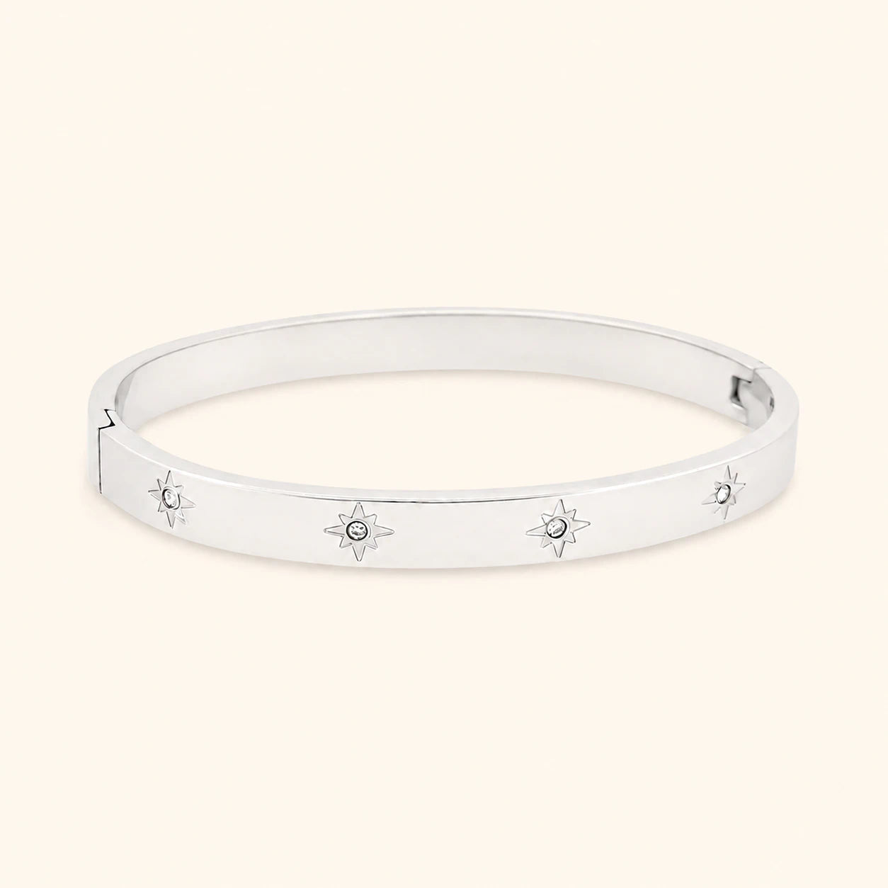 Silver bracelet with star designs on a light beige background